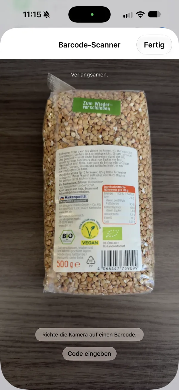 Screenshot des Barcode-Scanners in der App: Die Kamera zeigt eine Packung Buchweizen, darunter die Hinweise „Richte die Kamera auf einen Barcode.“ und „Code eingeben“.